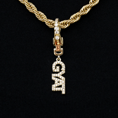 Colgante con dije "Gyat" con broche en oro amarillo
