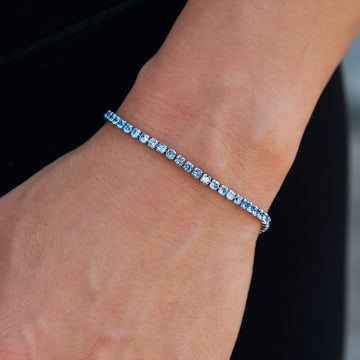 Brazalete de microtenis de topacio azul de 2 mm en oro blanco