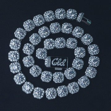 Clustered Tennis Necklace in white gold swirled in a circle around its own clasp. It is made up of multiple large stones surrounded by smaller stones each connected to each other. Clustered Tennis Necklace in white gold swirled in a circle around its own clasp. It is made up of multiple large stones surrounded by smaller stones each connected to each other.