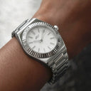 Alpha Era con bisel estriado de 36 mm en oro blanco