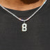 Dije número Micro Block en oro blanco