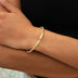 Pulsera de oro amarillo con dije de barra y corazón morado helado