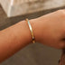 Brazalete abierto de oro amarillo con piedra engastada