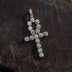 . 3/4 Inch Ankh Cross made up of large CZ stones and yellow gold plated lying flat on a black surface. 